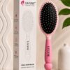Pink oval brush close-up showing ball-tip bristles on cushioned base